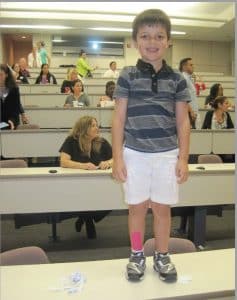 Boy Standing on desk with leg taping